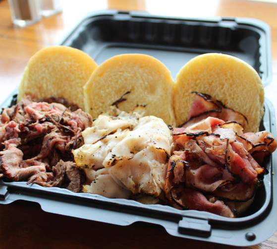 Take out containers with a selection of smoked meat sandwiches