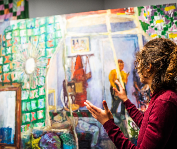 artist talking with art in background