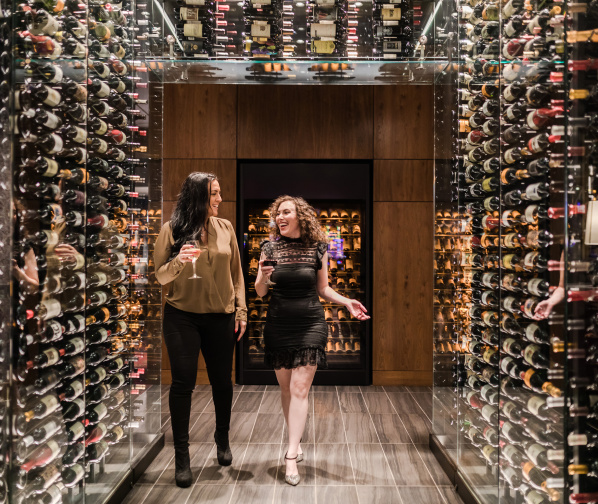 two women with wine walking in "wine tunnel"