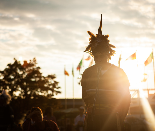 individual speaking into microphone with sunset behind