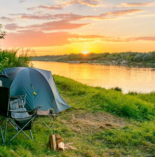 tent camping by the water at sunset