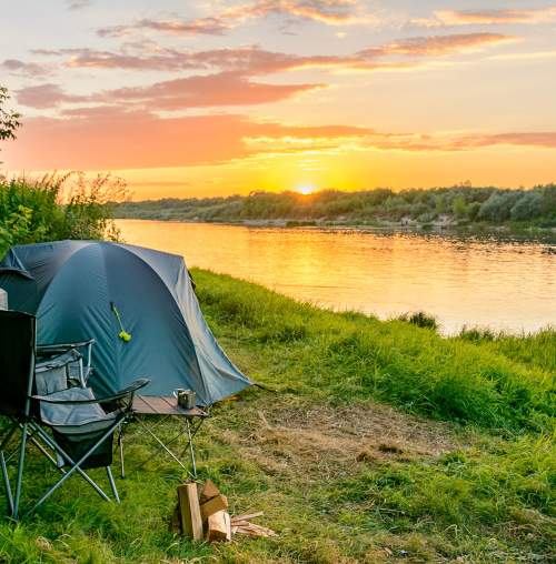tent camping by the water at sunset