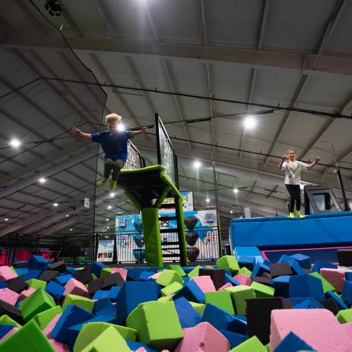 Two kids jumping into ball pit at Sky's the Limit