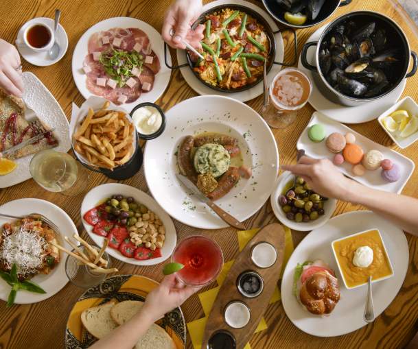 Round wooden table filled with various dishes for Carlisle dining