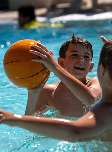 Family playing basketball in water at Discovery Bay