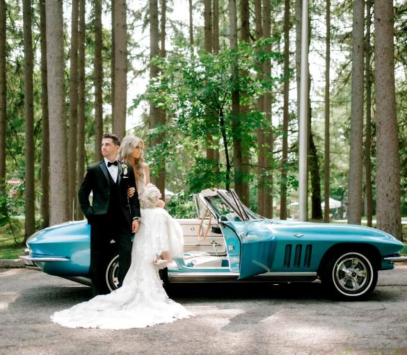 bride and groom in front of car