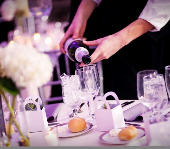 Server pouring champagne into a glass