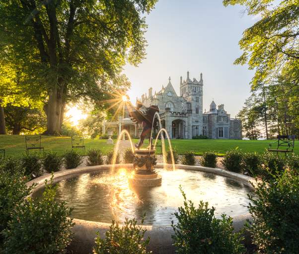 The sun sets over the Hudson River behind Lyndhurst Mansion.