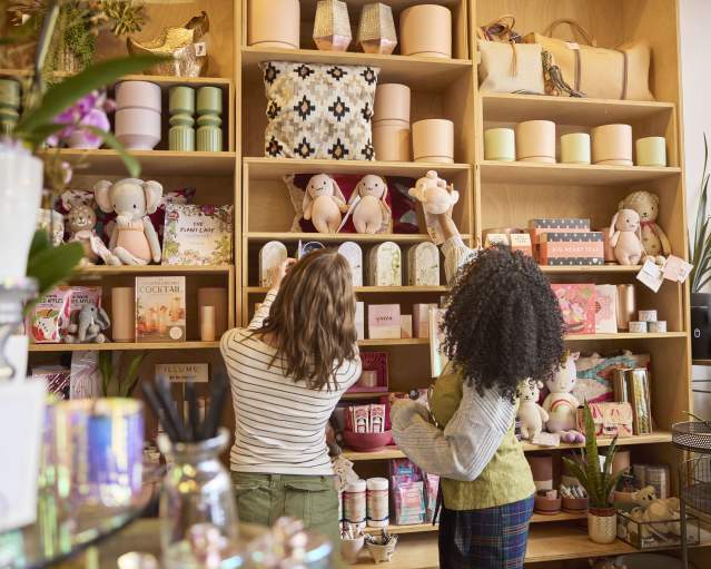 Two women look at shelves with gifts at a boutique