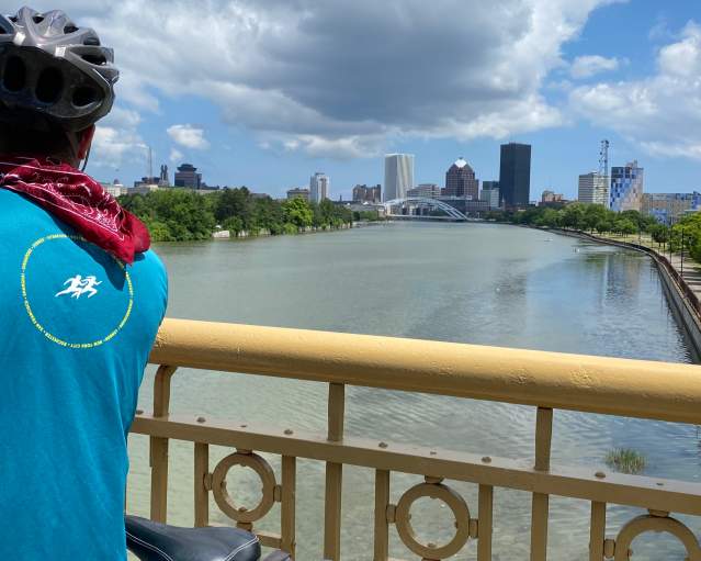 Cyclist looking out at Rochester skyline from Ford Street Bridge