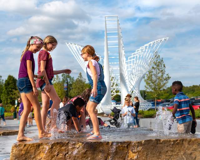 kids playing in the kids canal water feature at promenade park in fort wayne