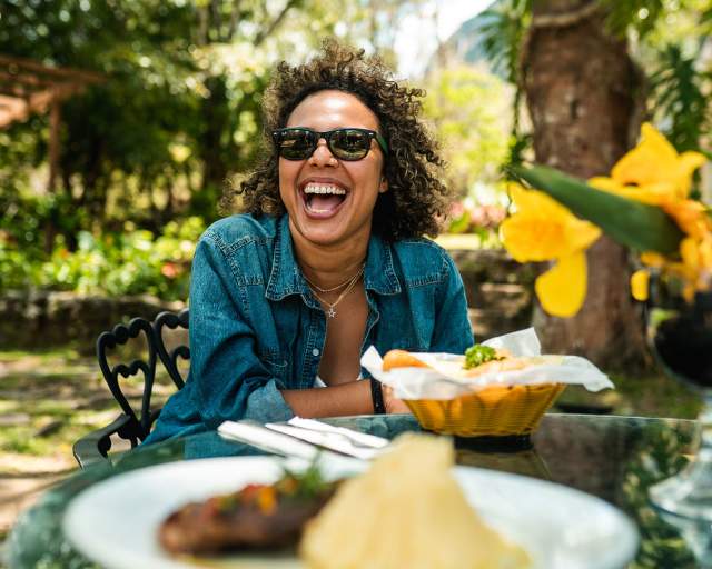 Woman smiling and enjoying Panamanian dishes at Los Mandarinos Boutique Hotel