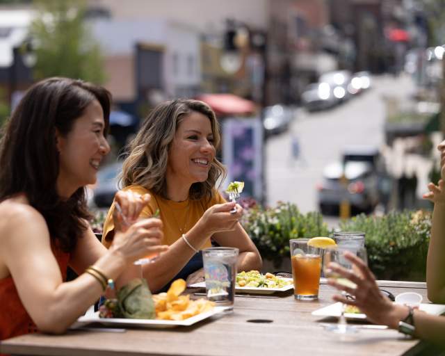 Three women eating lunch on a rooftop patio