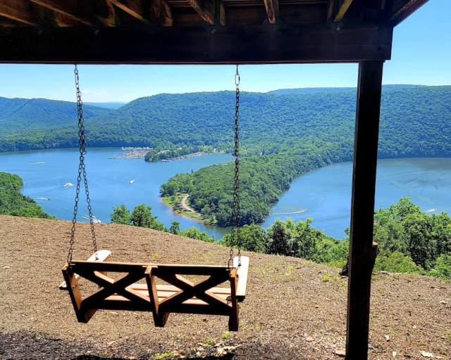 A swing overlooking a lake on a sunny day