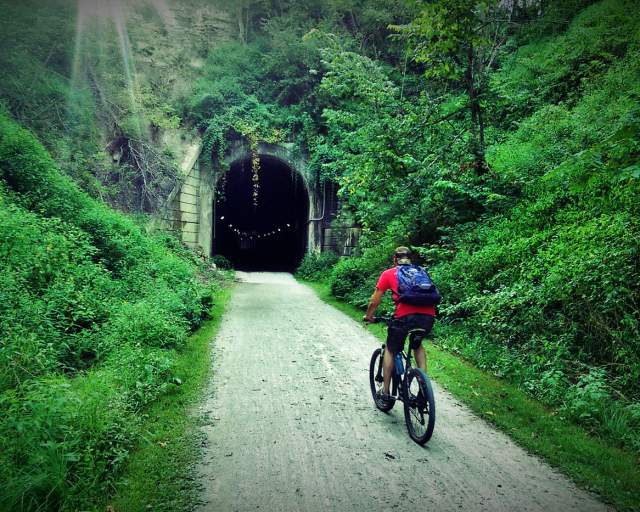 a person on bike riding Infront of a tunnel