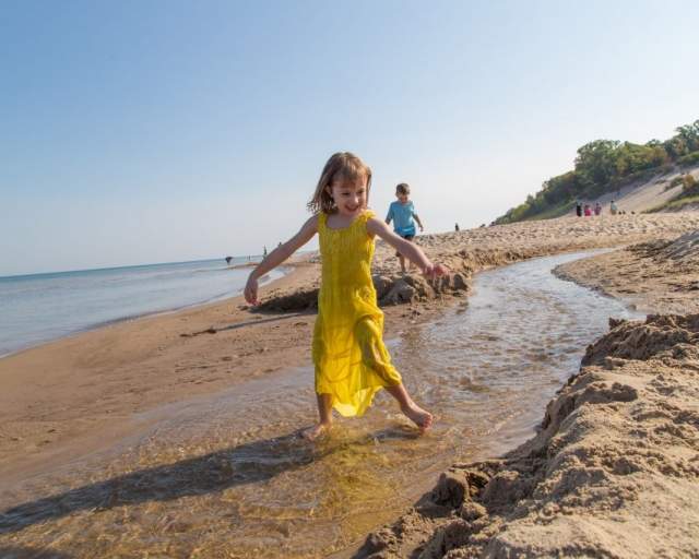 Girl playing in stream on beach