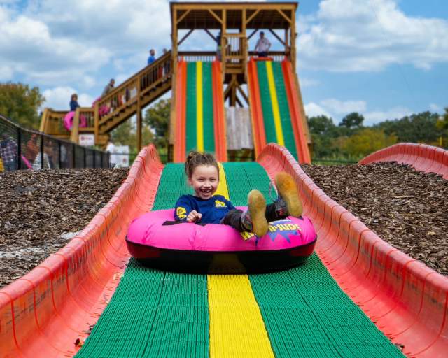 Girl sliding down a slide at Kersey Valley Attractions