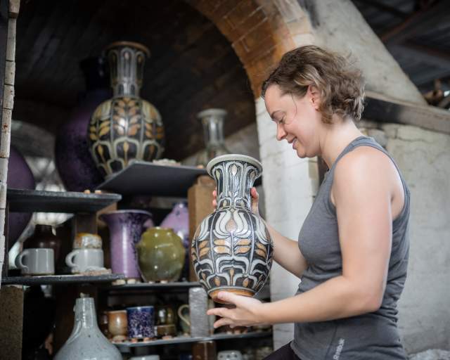 Seagrove Potter looking at a collection of Pottery
