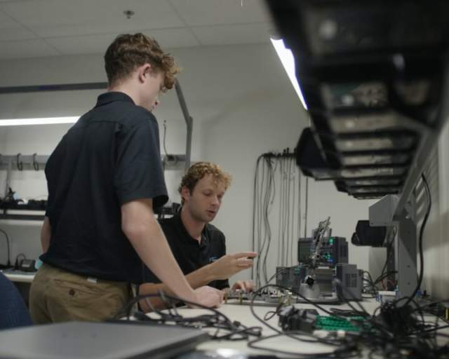 Two men working with electrical equipment