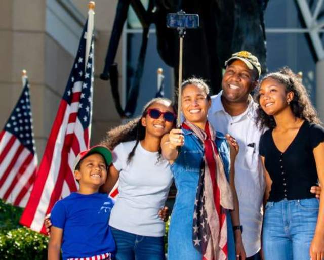 A family in front of Iron Mike at ASOM taking a selfie