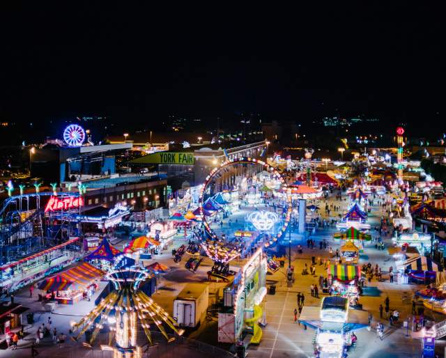 Aerial view of York State Fair at night with glowing rides