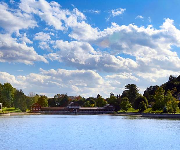 View of Onondaga Park with Blue Waters, Cloudy Blue Skies and Green Trees in Background