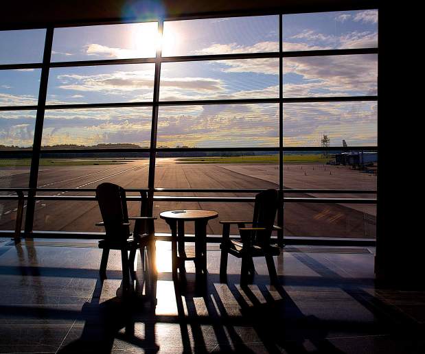 Bright Sunset Shines Through Window on Table and Chairs at Airport