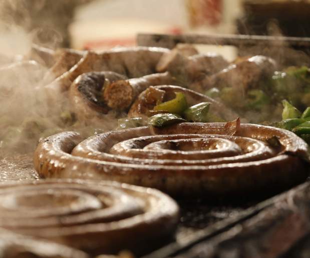 Sausages and Vegetables Cook on Grill as Steam Escapes