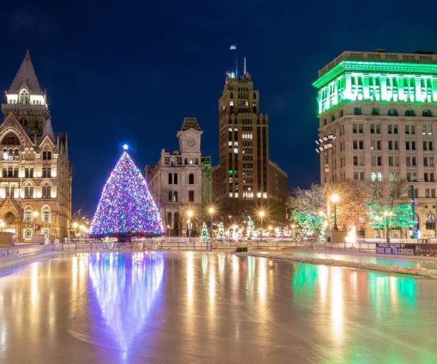Evening photo of Clinton Square Ice Rink and Holiday Tree lit up in Syracuse, NY