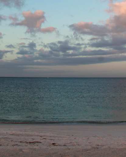 The Gulf of America at sunrise casts a rainbow of hues on Anna Maria Island, where the Bradenton Beach Scenic Highway runs parallel to the water.