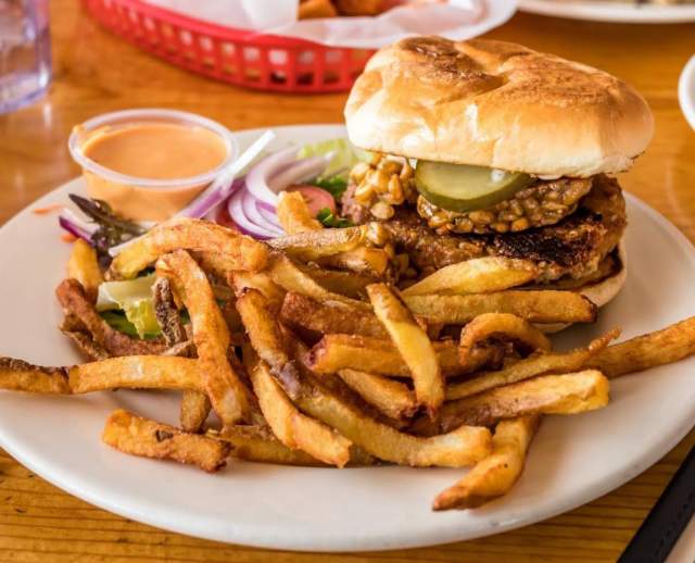 This house made vegan Mexicali burger with tempeh bacon and house made dill pickles at Vertical Diner will satisfy all of your cravings