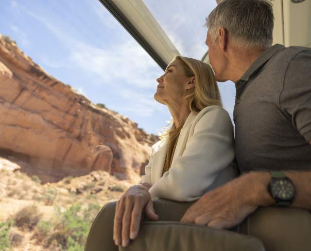 Two people staring out the window of the Canyon Spirit railway line in Utah.