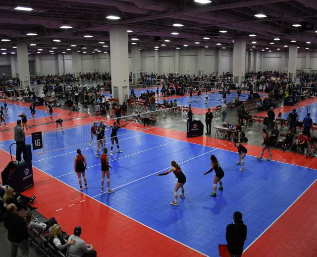 Mountain America Expo Center set up with volleyball courts, players on the court and spectators watching