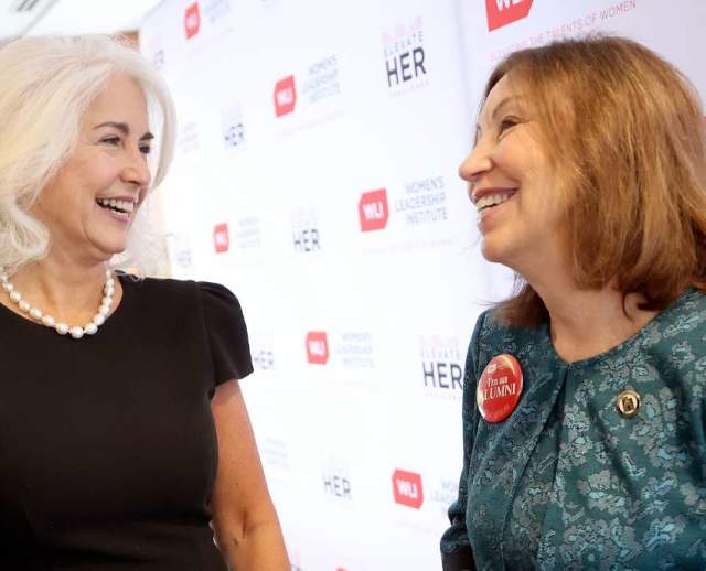 Two women speaking together, background says U Women Leadership Institute
