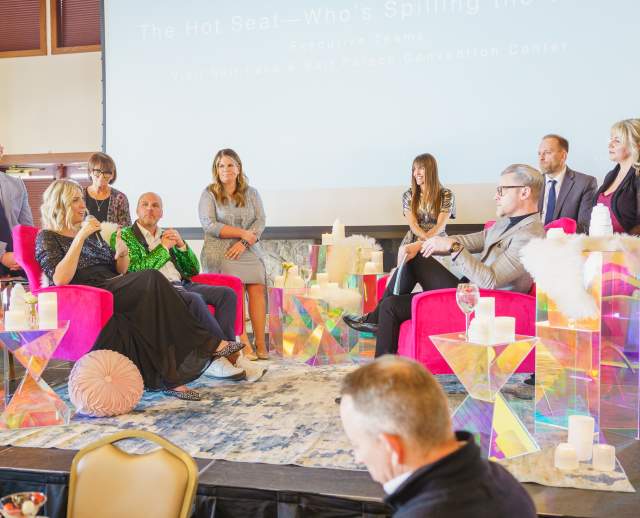 Leadership of Visit Salt Lake seated and standing on stage ready to present for the year in review