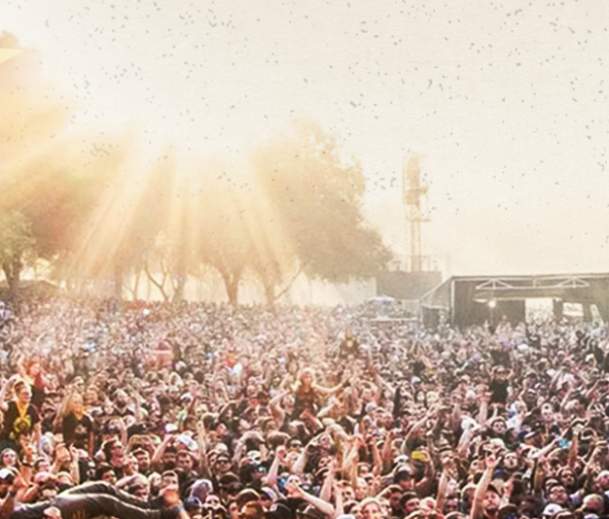 the back of someone on stage pointing out at a large crowd at the aftershock fesitval in sacramento