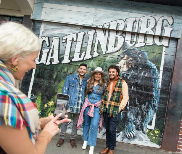 People Standing in front of a Gatlinburg mural