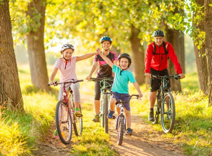 family of four two children at the front cycling on a sunny day