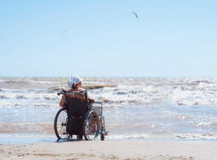 man in wheelchair on beach