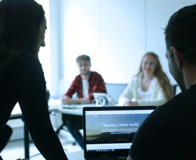 Group of people doing some research on a laptop.