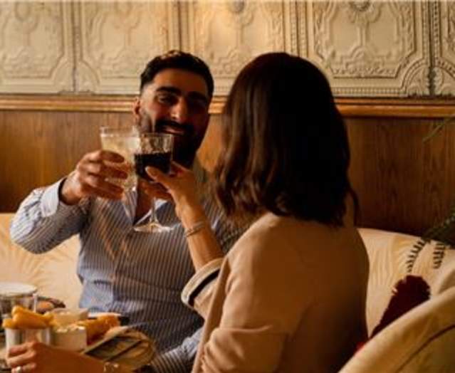 Photo of couple on a date at Valentine's raising their glasses
