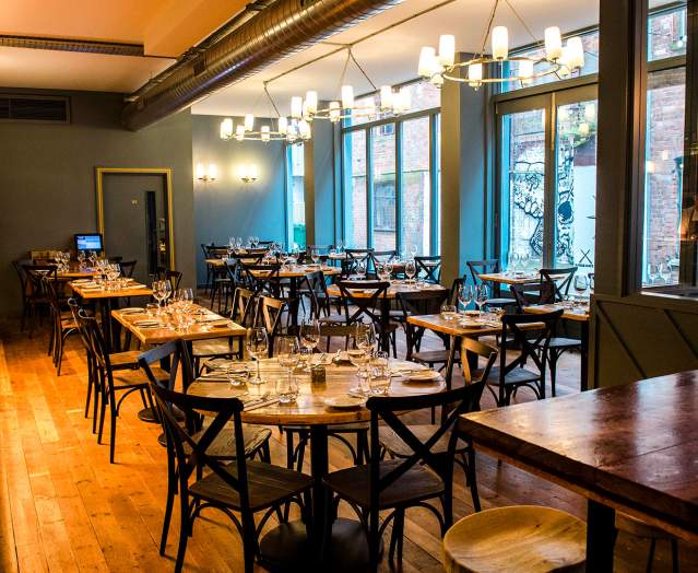 Interior of an empty restaurant with set tables at Muddlers Club Restaurant, Belfast.