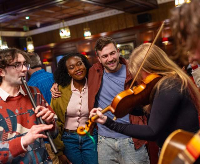 Group of musicians playing traditional Irish instruments in The Dark Horse in Belfast.