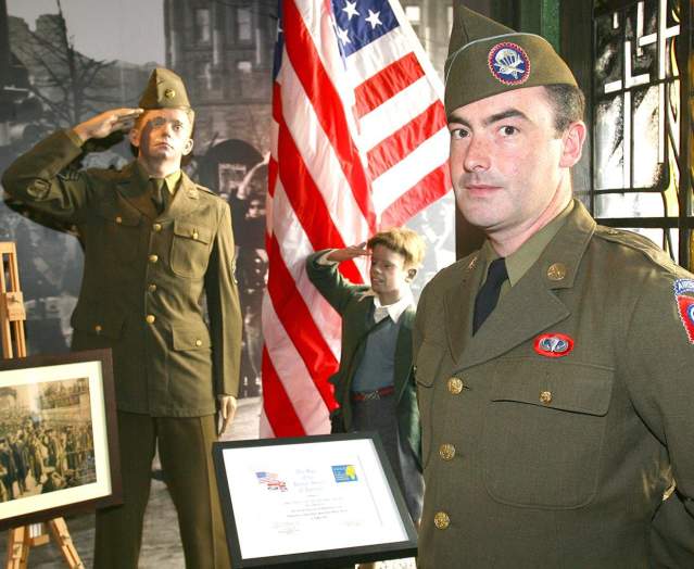 A man dressed up in a uniform from the Second World War standing in the gallery of the Northern Ireland War Memorial Museum