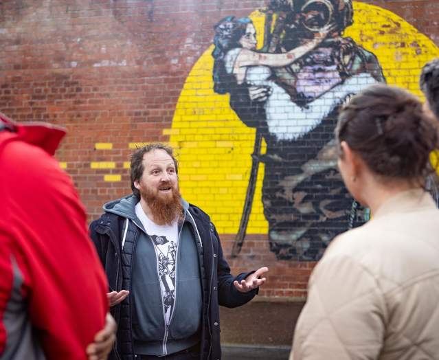 Tour guide with group on Seedhead Arts Street Art Walking Tour