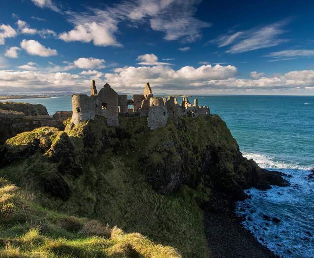 Medieval Dunluce Castle with blue skies.