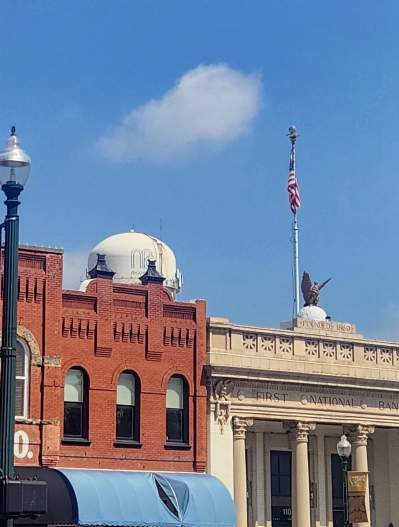Downtown McKinney roofline with 19th Hole banner