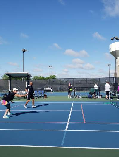 People on the tennis courts at The Courts Tennis Center