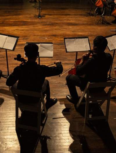 Cellos in a circle_wood floor_dramatic lighting