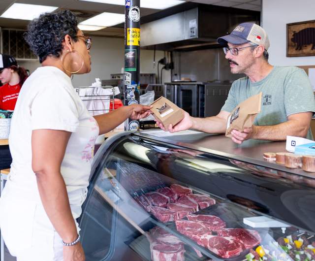 A woman purchases fresh meat from Noble Meats butcher shop near Spring Lake, NC.